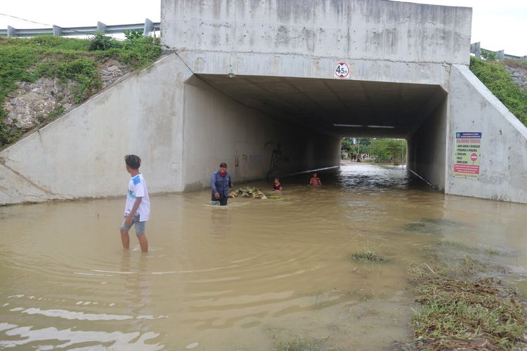 Kondisi Under Pass Jalan Tol Jombang - Kertosono, di Dusun Kedunggabus, Desa Bandar Kedungmulyo, Kabupaten Jombang, Jawa Timur, Kamis (11/2/2021). Warga setempat terpaksa menerobos banjir di tempat ini saat hendak memakamkan warga yang meninggal dunia.