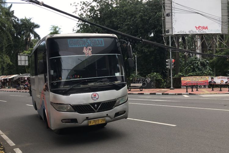 Sebuah bus menghindari kabel-kabel yang menjuntai di pertigaan Jalan Barito 1, Kramat Pela, Kebayoran Baru, Jakarta Selatan pada Jumat (26/2/2021) sore. 