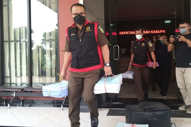 BARANG BUKTI—Kasi Pidsus Kejari Kabupaten Madiun, Bayu Novriandinata membawa sejumlah barang bukti berupa dokumen setoran pajak bumi bangunan perkotaan dan pedesaan (PBB P2) setelah bersama tim penyidik menggeledah Kantor Badan Pendapatan Daerah (Bapenda) Kabupaten Madiun, Jawa Timur, Kamis (29/4/2021) siang. Tim Kejari Kabupaten Madiun menggeledah kantor itu setelah kasus dugaan korupsi penyelewengan dana setoran PBB P2 senilai Rp 9,2 M naik ke penyidikan.