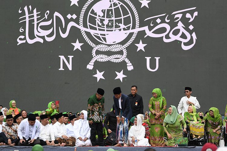 Presiden Joko Widodo (keenam kanan) disaksikan Ibu Negara Iriana Joko Widodo (kelima kanan), Ketua PBNU Said Aqil Siroj (tengah), Istri Gus Dur Sinta Nuriyah (kedua kanan), Ketua Muslimat NU Khofifah Indar Parawansa (keempat kanan) Ketua Pelaksana Harlah Yenny Wahid (ketiga kanan) bersiap memberikan sambutan pada Harlah ke-73 Muslimat Nahdlatul Ulama (NU), doa bersama untuk keselamatan bangsa dan maulidrrasul di Stadion Utama Gelora Bung Karno, Jakarta, Minggu (27/1/2019). Kegiatan yang diikuti ribuan peserta dari berbagai daerah tersebut mengangkat tema Khidmah Muslimat NU, Jaga Aswaja, Teguhkan Bangsa.