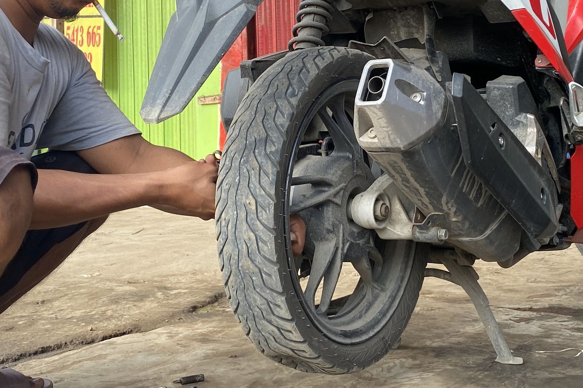 Ilustrasi proses tambal ban motor non-tubeless, masih menggunakan press karet