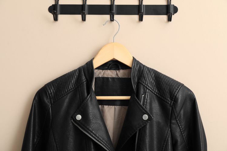 Ilustrasi menggantung jaket kulit dengan gantungan kayu.
