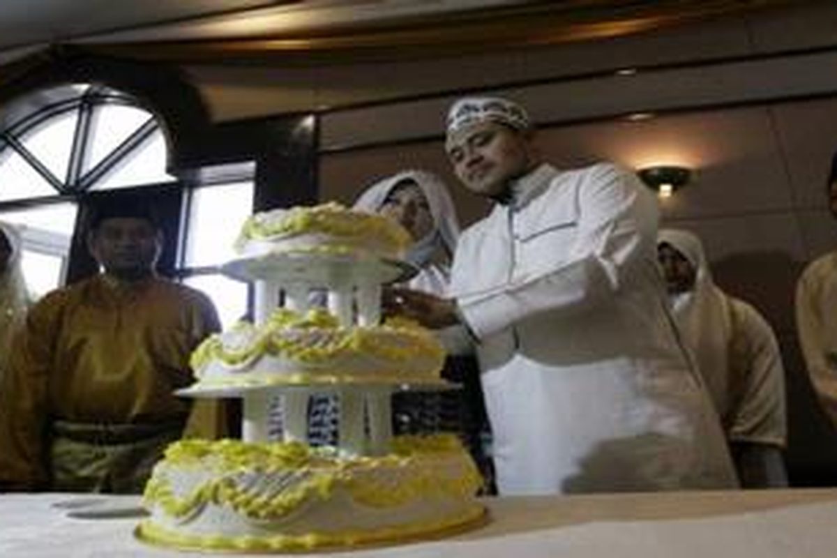 Sepasang pengantin peserta pernikahan massal yang digelar dalam rangka peresmian Klub Istri Taat Suami di Rawang, Malaysia, Sabtu (4/6/2011).