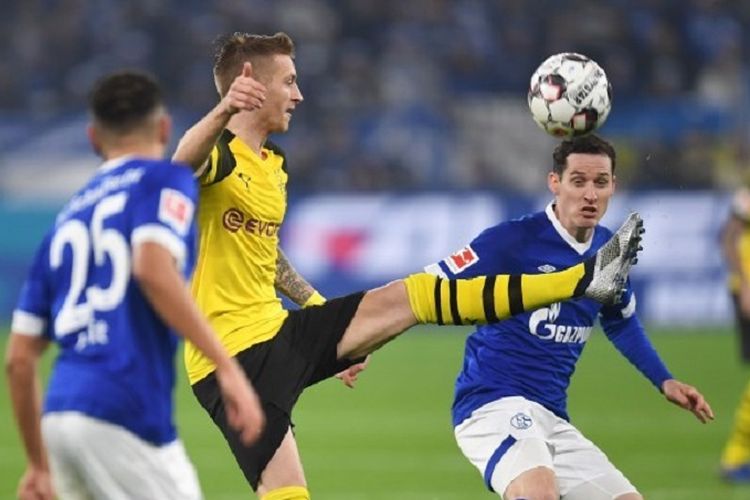 Marco Reus dikawal Sebastian Rudy pada laga Derbi Lembah Ruhr, Schalke 04 vs Borussia Dortmund, di Gelsenkirchen, dalam lanjutan Liga Jerman, 8 Desember 2018. 