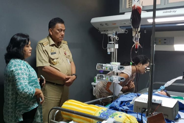 Gubernur Sulawesi Utara Olly Dondokambey (tengah mengenakan pakaian dinas) menyambangi Jessica yang tergolek lemah di Ruang PICU RSUP Kandou Manado, Senin (22/10/2018).