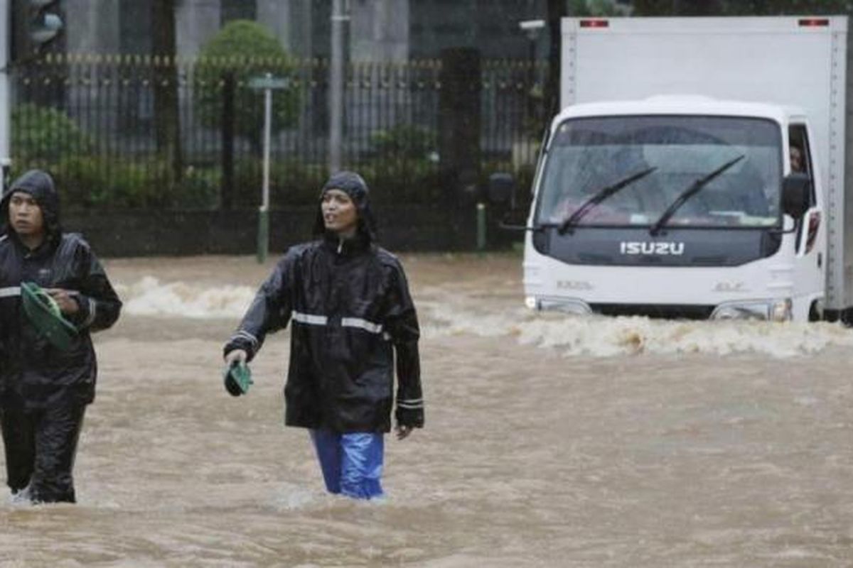 Warga melintasi banjir di Jakarta Pusat, Senin (9/2/2015). Curah hujan yang tinggi mengakibatkan sejumlah tempat di ibu kota terendam banjir.
