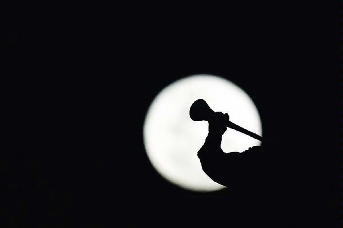 Seorang suporter, yang tergambar siluet oleh bulan, meniup vuvuzela sebelum laga 16 besar antara Amerika Serikat dan Ghana di Stadion Royal Bafokeng, Rustenburg, 26 Juni.