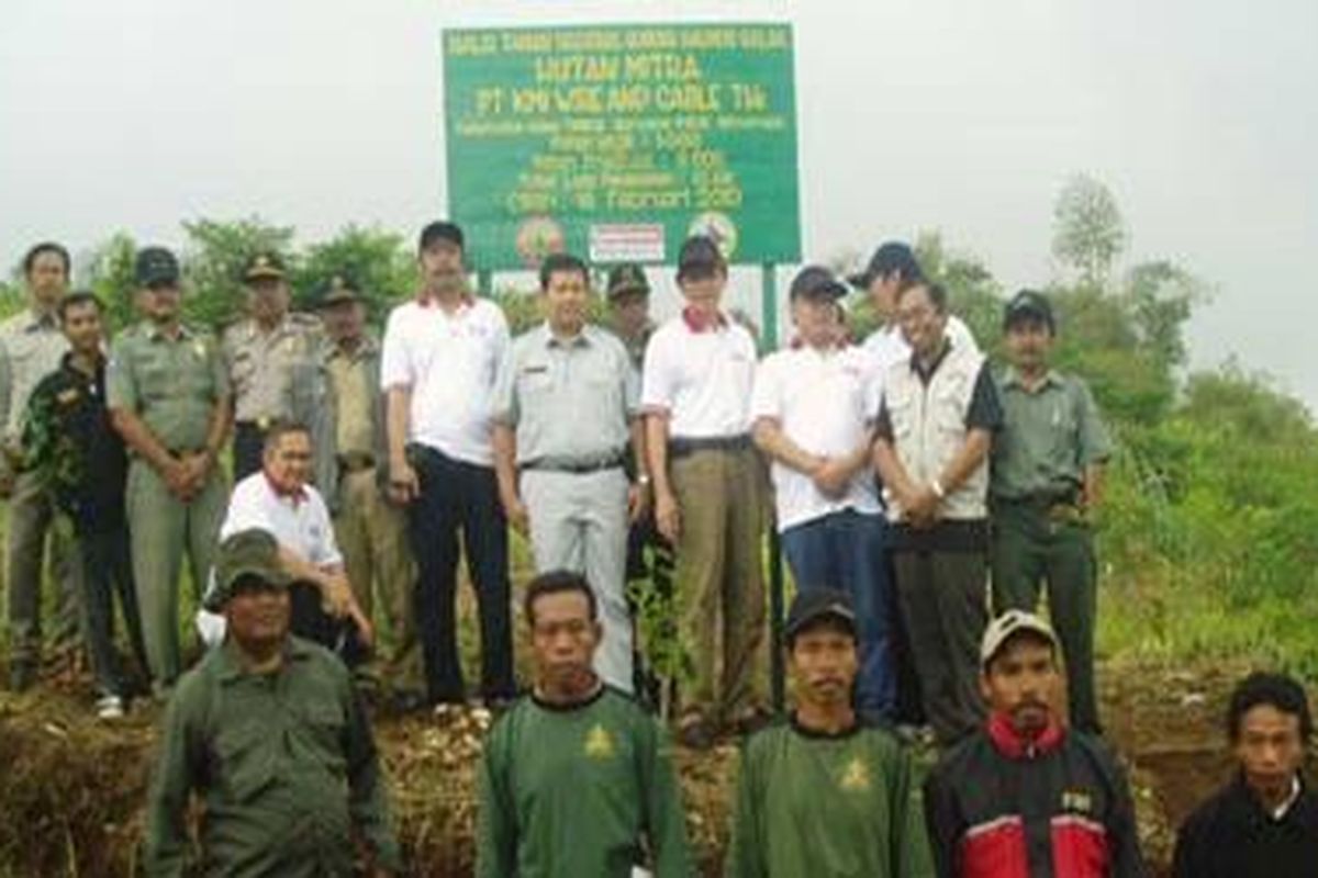Chief Operation PT KMI Wire and Cable Tbk Lie Thian Han (berkaus putih) saat secara simbolik menanam pohon rasamala (Altingia excelsa) di hutan kritis di kawasan Taman Nasional Gunung Halimun Salak (TNGHS), Rabu (18/2/2010). Bersamanya adalah Kepala Balai TNGHS Bambang Supriyanto dan seorang petani masyarakat MKK Sirnarasa. PT KMI bersama masyarakat menanam 10.000 pohon untuk merestorasi hutan kritis di kawasan TNGHS.