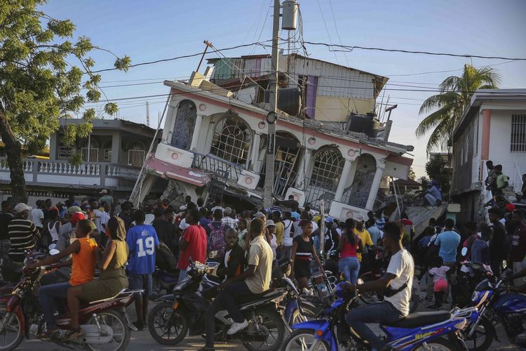 Orang-orang berkumpul di luar Petit Pas Hotel, yang hancur akibat gempa Haiti di Les Cayes, Sabtu (14/8/2021). Gempa berkekuatan magnitudo 7,2 ini berpusat 125 kilometer barat ibu kota Port-au-Prince, menurut Badan Survei Geologi Amerika Serikat (USGS).
