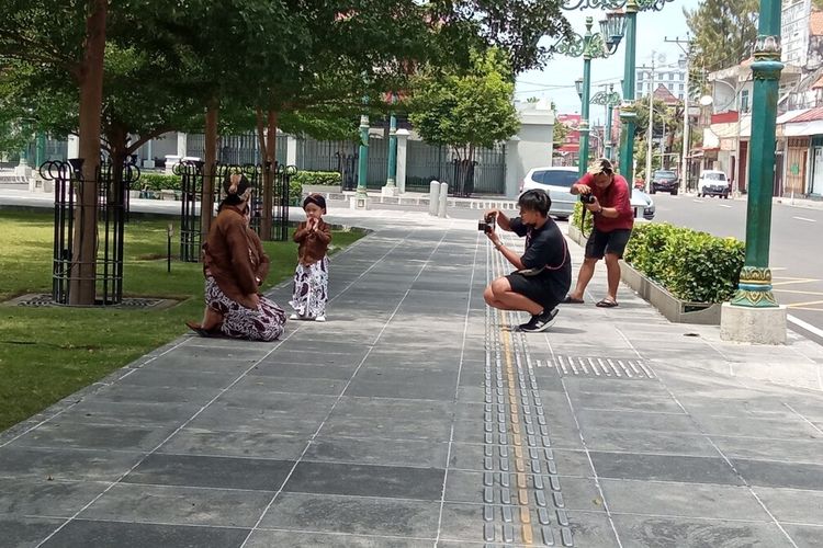 Habib (baju hitam) saat memotret wisatawan yang menggunakan jasanya, Rabu (1/9/2021)