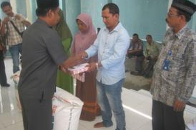 ASisten I Pemkab Bireuen, Murdani, menyerahkan santunan kepada ahli waris korban meninggal dalam insiden beradarh di Kecamatan Peulimbang, setahun silam. (DESI)