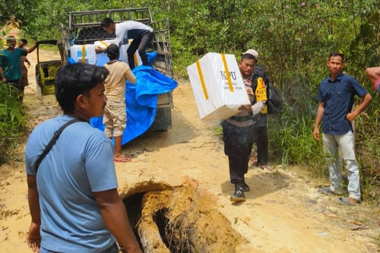 Petugas dan warga memindahkan logistik pemilu dari mobil ke dalam pompong karena akses jalan darat putus menuju Desa Rantau Kasih, Kecamatan Kampar Kiri Hilir, Kabupaten Kampar, Riau, Senin (12/2/2024).
