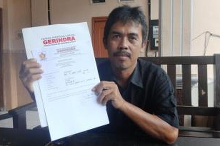 Jumadi, tukang servis kompor gas, warga Kelurahan Gebang, Kecamatan Patrang, Jember, Jawa Timur, menunjukkan formulir pendaftaran bakal calon bupati dari Partai Gerindra.