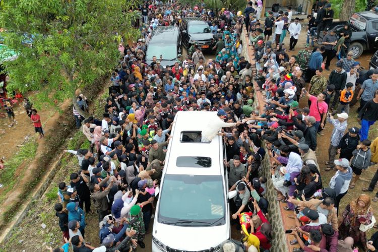 Prabowo membagikan cokelat kepada masyarakat saat berkunjung ke Desa Karanganyar, Jampang Kulon, Kabupaten Sukabumi, Jawa Barat, Sabtu (30/12/2023).