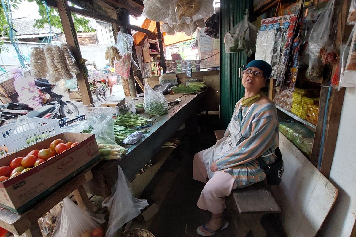 Tasrinah (58) warga penjual sayuran di Kembangan Utara, Kembangan, Jakarta Barat, terpaksa tidur di atas meja sayur saat Kali Angke meluap.