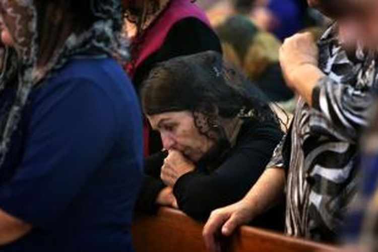 Seorang perempuan Irak penganut Kristen sedang berdoa di sebuah gereja di kota Arbil, ibu kota daerah otonomi Kurdi, Minggu (20/7/2014). Umat Kristen sudah hidup di Irak selama lebih di 16 abad namun pekan lalu mereka dipaksa meninggalkan kota Mosul yang dikuasai ISIS.
