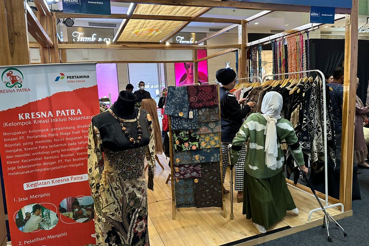 Penyandang disabilitas tuna daksa sekaligus perajut kain, Elis Juarsih (47, baju hijau putih) sedang melayani calon pembeli yang datang ke pameran Pertamina Small Medium Enteprise Expo (SMEXPO) 2023 di Mal Gandaria City, Kebayoran Lama, Jakarta, Sabtu (4/11/2023). Elis adalah pelaku Usaha Mikro Kecil Menengah (UMKM) penyandang disabilitas yang diajak berpartisipasi oleh Pertamina dalam pameran Pertamina SMEXPO sebagai penerapan program Sobat Istimewa.. Mereka mendapatkan stan untuk mempromosikan produk yang diproduksi oleh kelompok penyandang disabilitas.