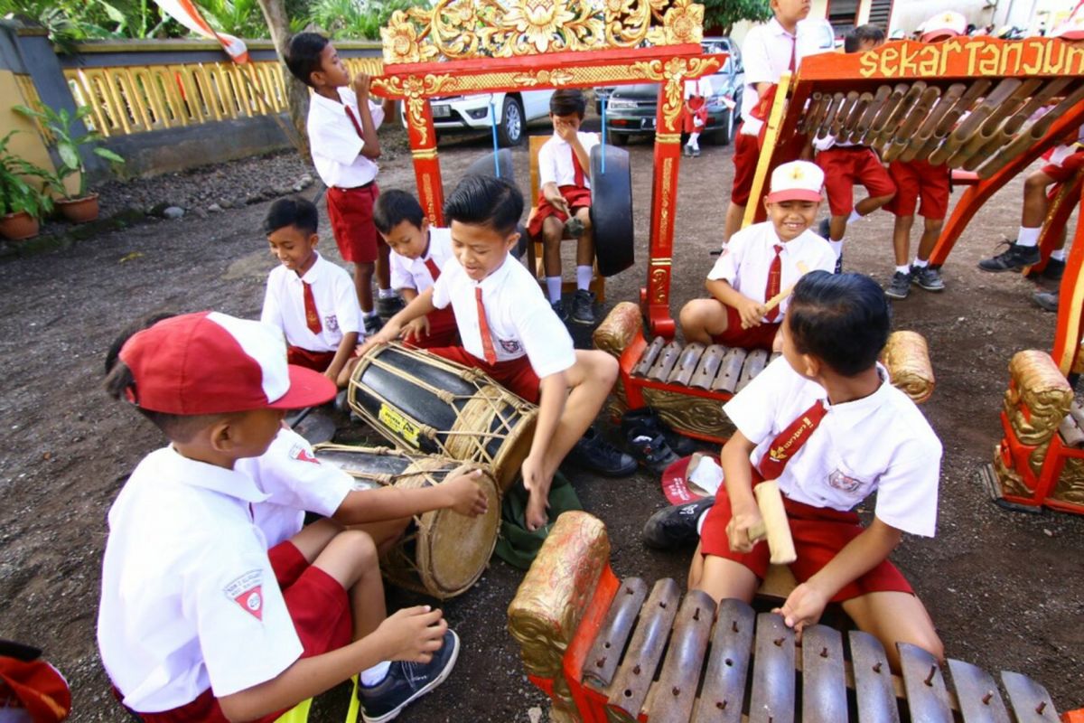 Siswa SDN 2 Alasmalang, Kecamatan Singojuruh, Banyuwangi, Jaawa Timur, belajar musik tradisional angklung gamelan di halaman sekolahnya, Kamis (8/2/2018).