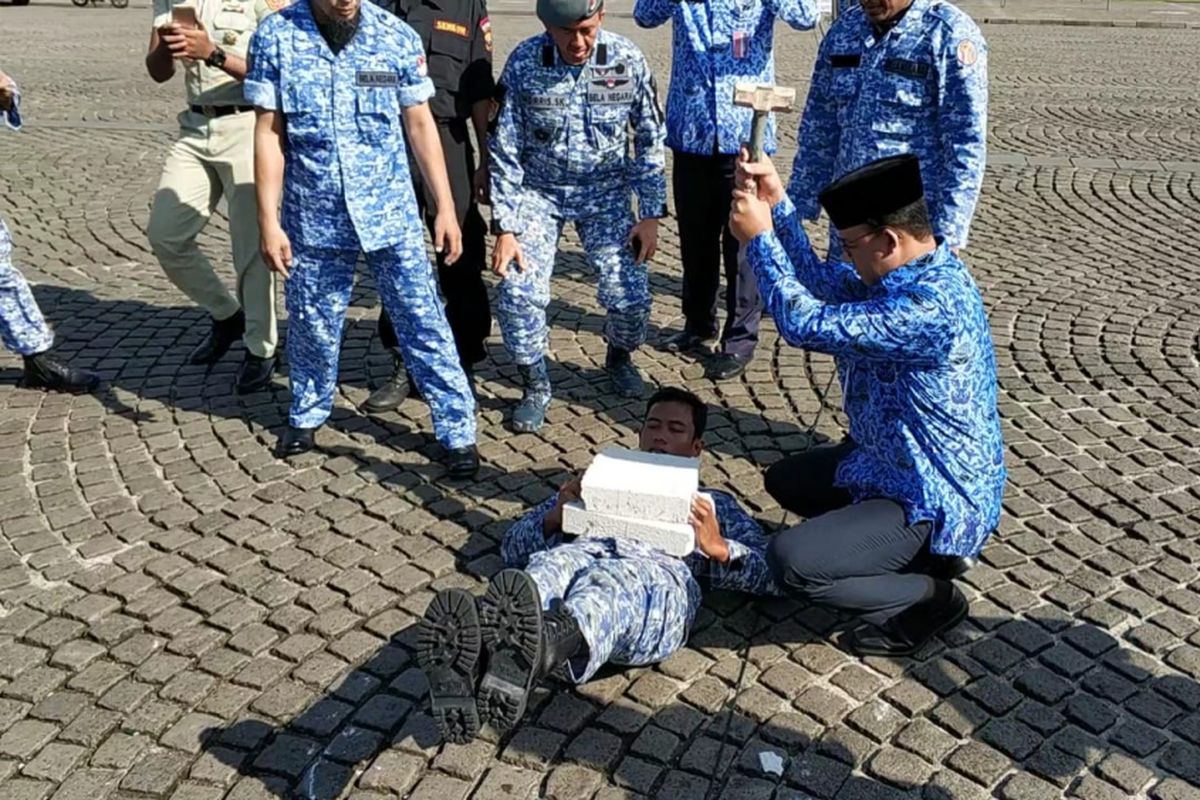 Gubernur DKI Jakarta Anies Baswedan berpartisipasi dalam atraksi memecahkan beton dan mematahkan besi dalam Upacara Hari Bela Negara di Monas, Rabu (19/12/2018).