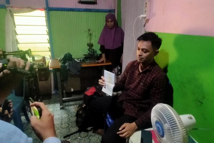 Andi Raiwansah saat memperlihatkan Paspor di rumahnya