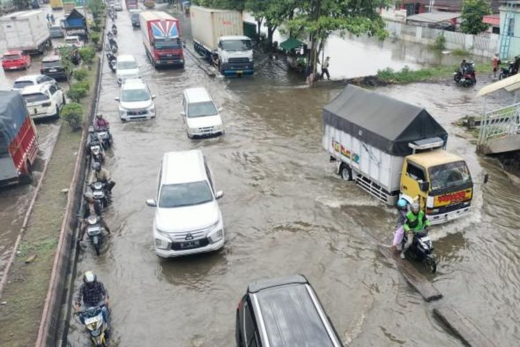 Sejumlah kendaraan yang melintasi di jalan Kaligawe Semarang terdampak banjir yang diakibatkan hujan deras semalam. Banjir menyebabkan ketersendatan arus lalu lintas,  