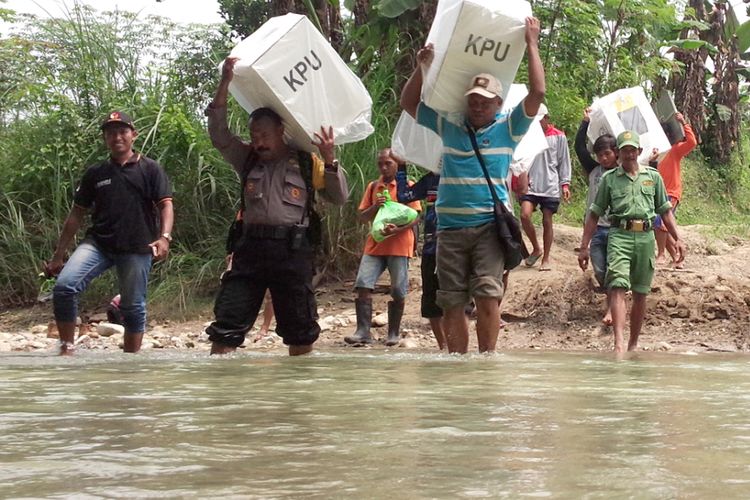 Para petugas menyeberangi sungai Beng saat mendistribusikan kotak suara berisi surat suara Pemilu 2019 untuk TPS 10 di Dusun Nampu Desa Klitih Kecamatan Plandaan Kabupaten Jombang, Selasa (16/4/2019).