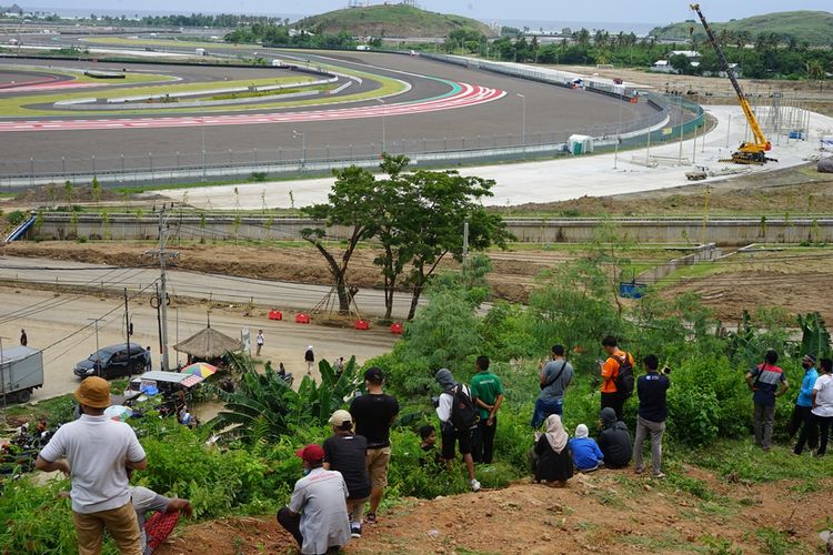 Warga menonton tes pramusim MotoGP 2022 dari atas bukit yang terletak sisi kiri area depan Sirkuit Mandalika, Sabtu (12/2/2022).