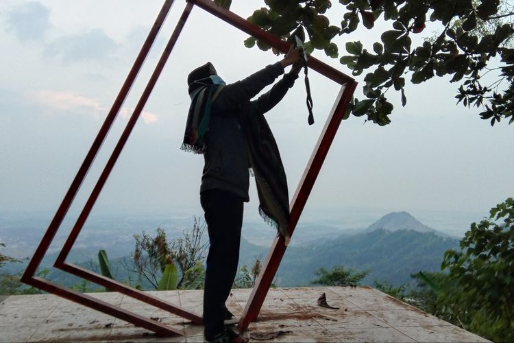 Seorang pengunjung tengah mendokumentasikan pemandangan dari atas Puncak Sempur, Desa Cintalaksana, Kecamatan Tegalwaru, Kabupaten Karawang, Kamis (20/8/2020).