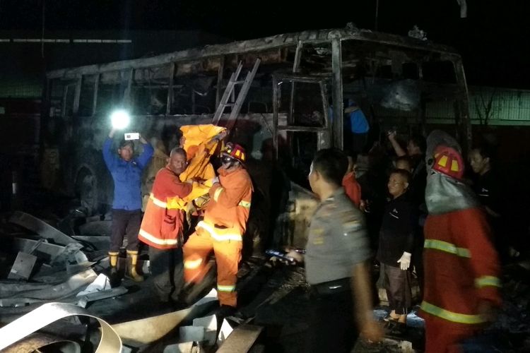 Petugas Pemadam Kebakaran Mengevakuasi Korban Tewas Akibat Kebakaran SPBU di Kabupaten Jember, Jawa Timur. Korban Tewas Ditemukan Di Dalam Bus Yang Ikut Terbakar.