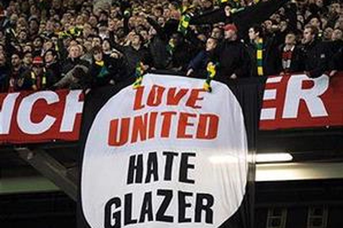 Pendukung Manchester United memegang spanduk anti-Glazer.