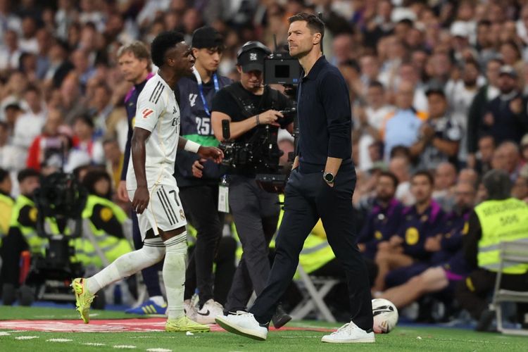 Penyerang Real Madrid, Vinicius Junior, berjalan melewati pelatih Xabi Alonso saat ia digantikan pada laga Liga Spanyol antara Real Madrid CF dan FC Barcelona di Stadion Santiago Bernabeu di Madrid pada 26 Oktober 2025.