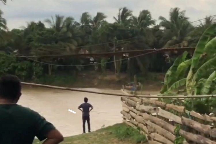 Pemuda terhempas angin di Muara Enim, Sumatera Selatan saat melintas di atas jembatan gantung.