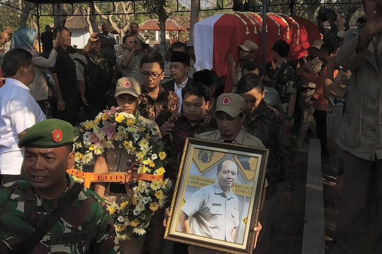Peti jenazah Sutopo dipanggul para petugas BPBD sebelum dimasukkan ke liang lahat di TPU Sasonolayu, Siswodipuran, Boyolali, Jawa Tengah, Senin (8/7/2019).