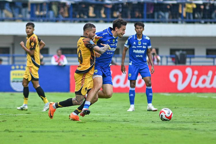 Aksi bintang Persib Bandung Thom Haye berduel dengan top skor Persija Jakarta Maxwell Souza pada laga yang berlangsung Minggu (11/1/2026) di Stadion Gelora Bandung Lautan Api (GBLA). 
