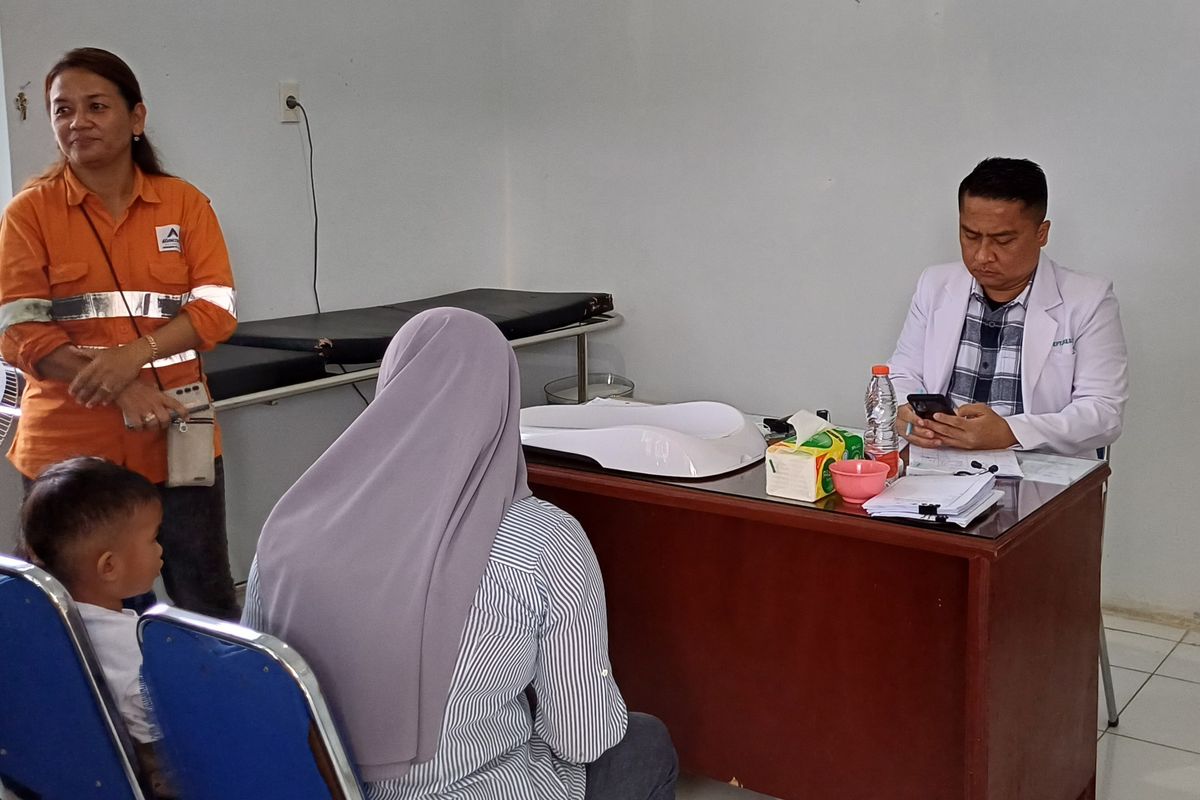 Seorang warga bernama Aminah (40) saat mengajak anaknya berobat di Puskesmas Batang Toru, Tapanuli Selatan, Sumatera Utara 