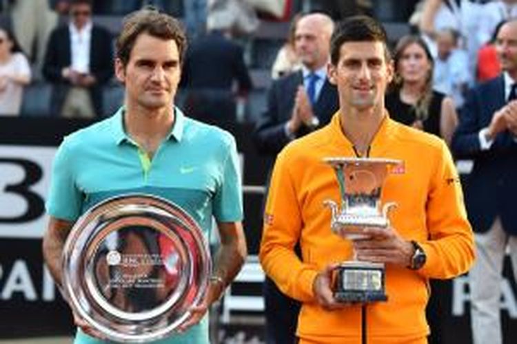 Petenis Serbia, Novak Djokovic (kanan), memegang trofi juara Roma Masters setelah mengalahkan petenis Swiss, Roger Federer (kiri), pada laga final, Minggu (17/5/2015). Djokovic menang 6-4, 6-3.