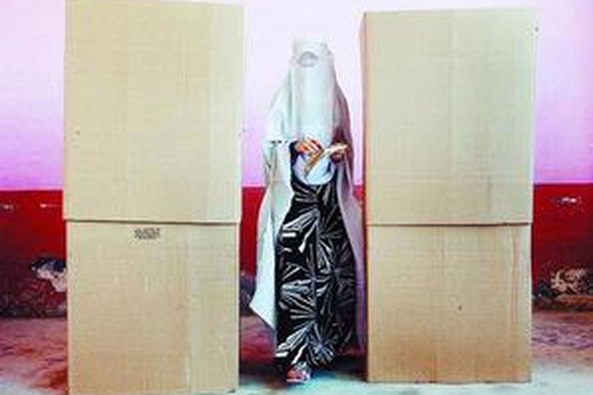 Seorang wanita meninggalkan salah satu lokasi pencoblosan di Mazar-i-Sharif, Afganistan utara, Kamis (20/8). 