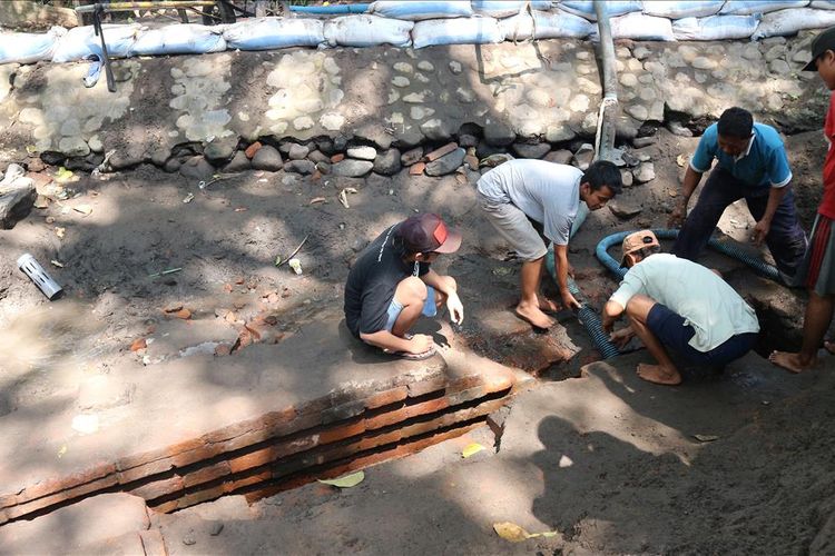 Warga Dusun Sumberbeji, Desa Kesamben, Kecamatan Ngoro, Kabupaten Jombang, Jawa Timur, membersihkan waduk yang bersumber dari sumber mata air alami, di Dusun setempat, Minggu (30/6/2019).