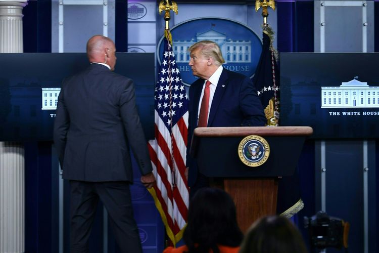 Presiden Amerika Serikat (AS) Donald Trump segera diajak oleh anggota Secret Service keluar dari Ruang Konferensi Pers Brady di Gedung Putih, Washington DC, pada 10 Agustus 2020, setelah penembakan dilaporkan terjadi.