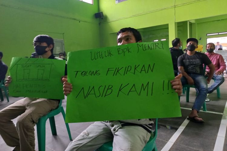 Salah satu pekerja toilet membentangkan poster meminta Menteri BUMN Erick Thohir mengkaji ulang pernyataan soal WC SPBU gratis di Sukahening, Kabupaten Tasikmalaya, Jawa Barat, Minggu (12/12/2021).