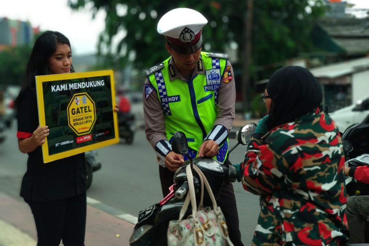 Petugas kepoliian dari NTMC Polri memberikan penyuluhan tentang tertib berkendara bersama kampanya Gerakan Tertib Lalu Lintas (Gatel) Otomania.com