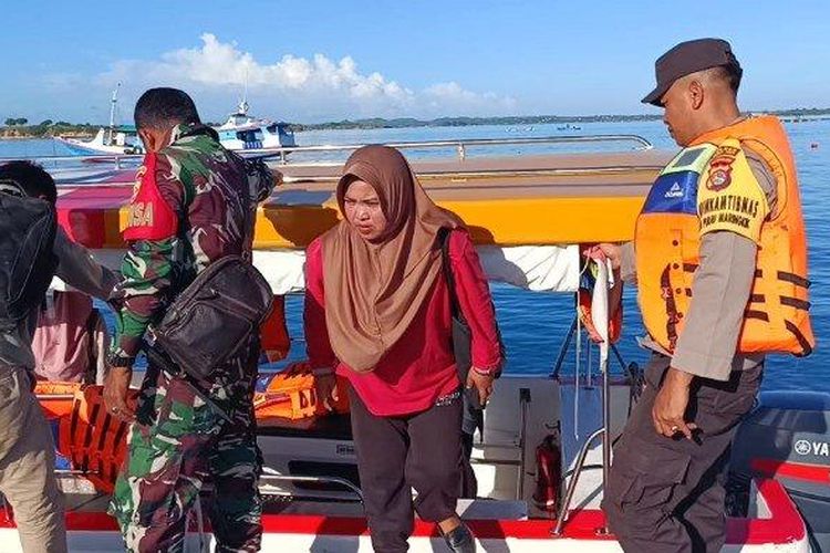 ErniSrianti (37) saat turun dari perahu kayu milik nelayan untuk mengajar di Pulau Maringkik. Ia rela menyebrangi laut demi memenuhi tugasnya sebagai guru. (Tribun Lombok/Ahmad Wawan Sugandika)