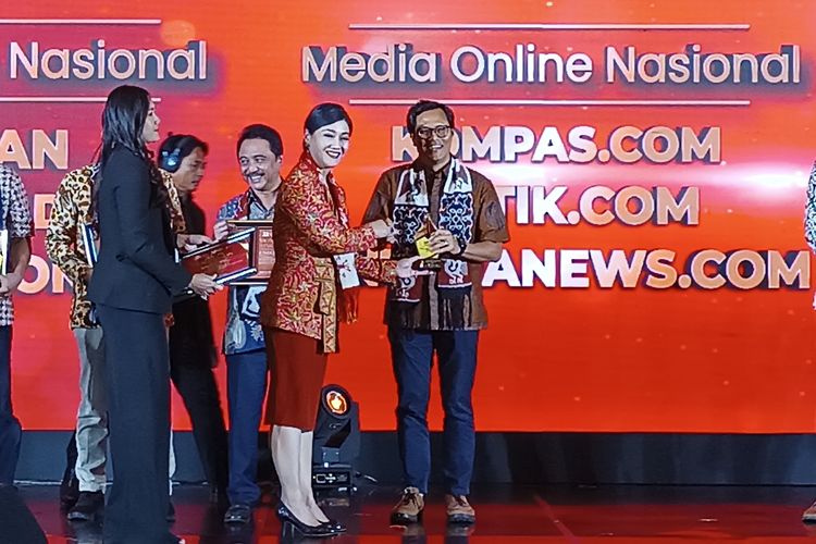 Pemimpin Redaksi Kompas.com Wisnu Nugroho menerima penghargaan dari Kepala Eksekutif Pengawas Perilaku Usaha Jasa Keuangan, Edukasi dan Pelindungan Konsumen OJK Friderica Widyasari Dewi  dalam acara Apresiasi Media Massa 2023, Senin (27/11/2023) di Jakarta. 