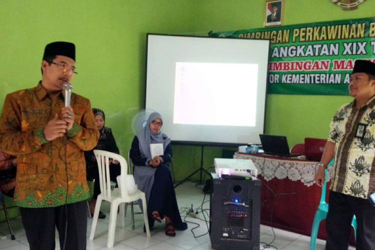 Kepala Kantor Kemenag Jombang, Abdul Haris (pegang mic), saat menyampaikan rencana penerbitan kartu nikah kepada belasan pasangan calon pengantin di Kantor Urusan Agama (KUA) Kecamatan Jombang, Kamis (15/11/2018).