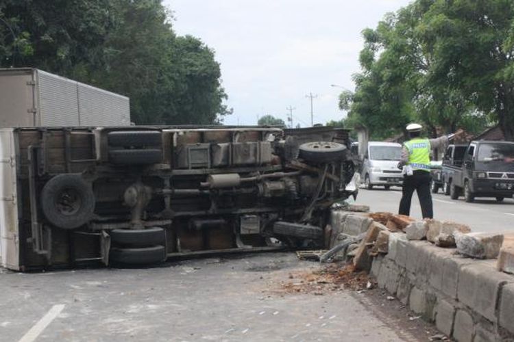 Truk bermuatan bawang yang terperosok lubang jalan di jalur Pantura Kendal, Jawa Tengah, Sabtu (4/2/2017). 