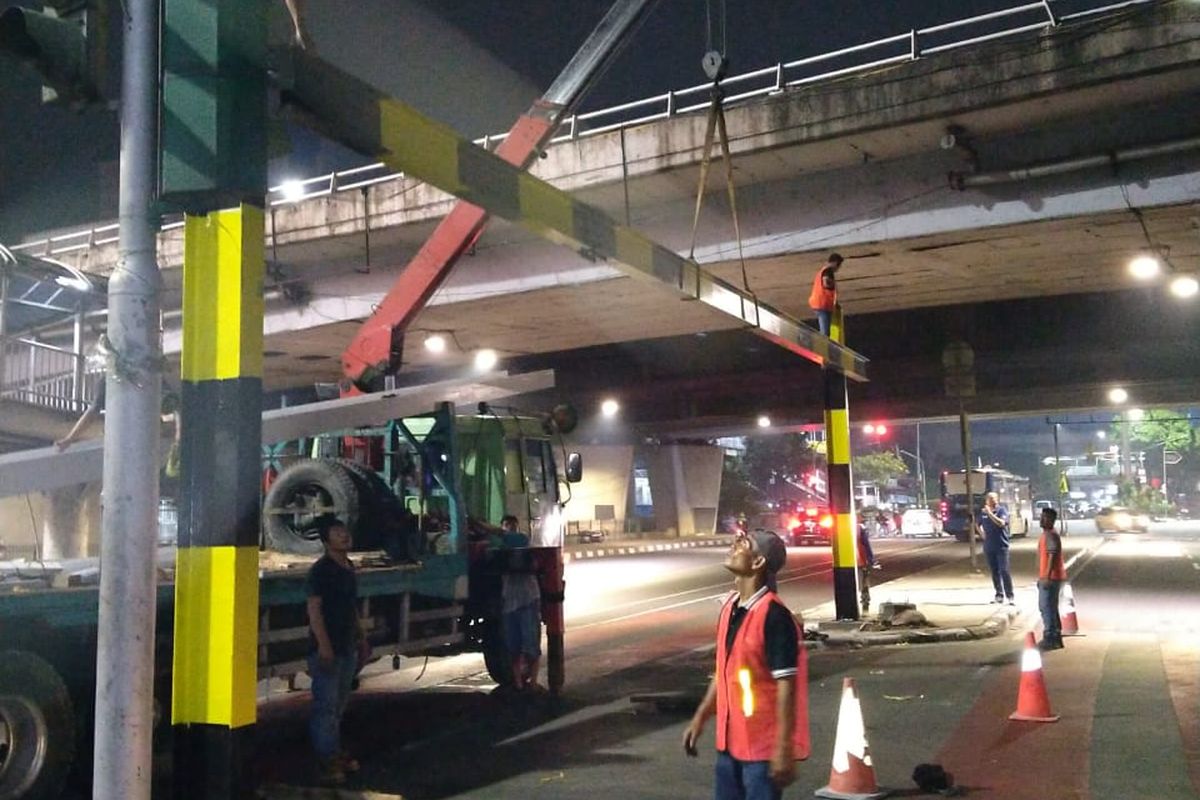 Petugas sedang memperbaiki JPO dan tiang Buffer di Halte TransJakarta Grogol, Jakarta Barat.