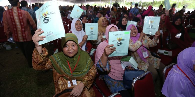Sejumlah warga menunjukkan sertifikat tanah yang diberikan  Presiden Republik Indonesia Joko Widodo (Jokowi) saat acara penyerahan sertifikat tanah di Serpong, Tangerang Selatan, Banten,  Rabu  (11/10/1017). Jokowi  menyerahkan 10.100 sertifikat tanah kepada warga Tangerang Raya.
