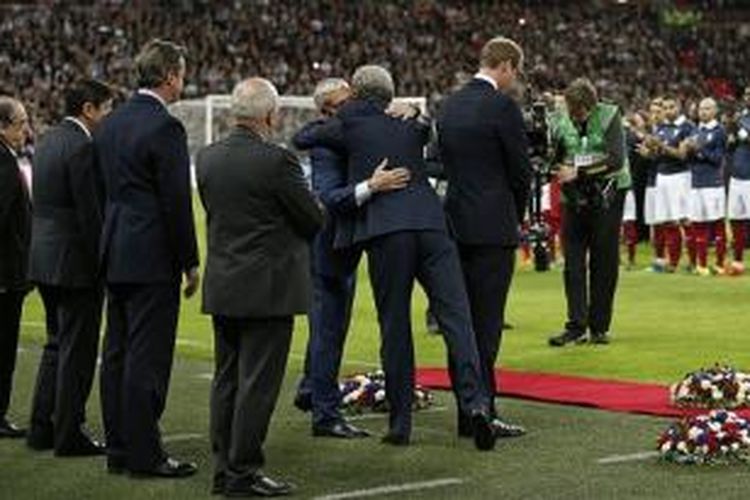 Didier Deschamps dan Roy Hodgson berpelukan di belakang Pangeran William, jelang Inggris vs Perancis, Selasa (17/11/2015). 