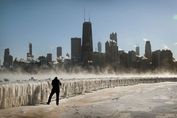 
Seorang pria di sepanjang tepi danau saat suhu udara berkisar minus 20 derajat Celsius pada 30 Januari 2019, di Chicago. 