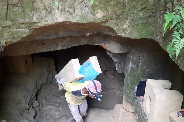 Perajin Pawon saat membawa bongkahan batu dari dalam goa di Dusun Ningalan, Desa Ngraho, Kecamatan Kedungtuban, Kabupaten Blora, Jawa Tengah, Sabtu (15/7/2023)